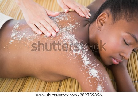Pretty woman enjoying a salt scrub massage at the health spa
