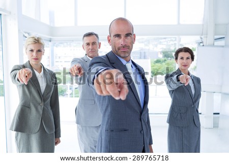 Business team pointing at the camera in the office