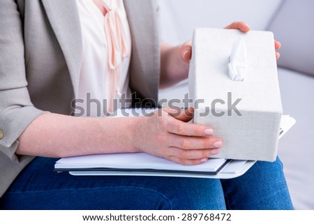 Businesswoman holding paper tissue box in office