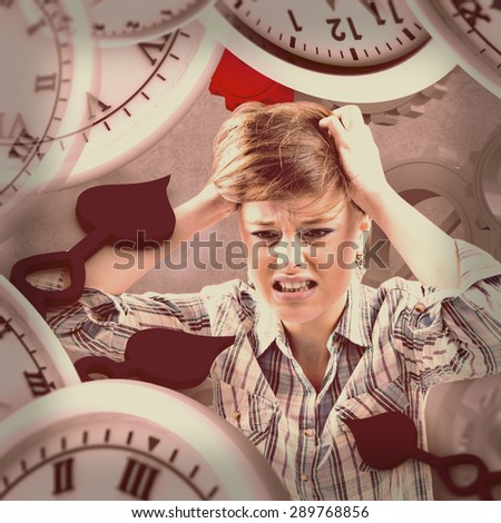 Pretty brunette getting a headache with hands on head against grey background