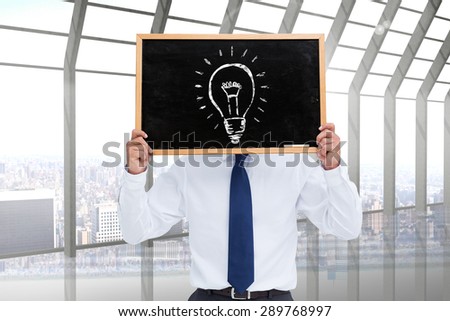 Businessman showing board against room with large window looking on city