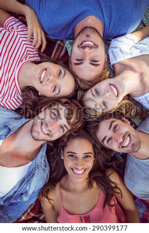 happy friends in a park huddling in circle on a sunny day