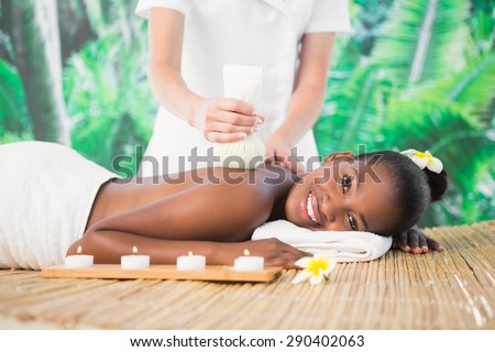 Side view of a pretty woman enjoying a herbal compress massage at the health spa