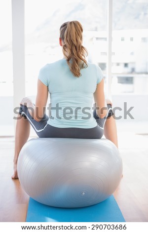 Woman sitting on exercise ball in fitness studio