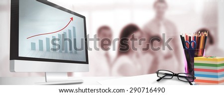 Computer screen against blue bar chart with red arrow