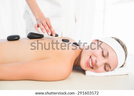 Beautiful blonde enjoying a hot stone massage at the health spa