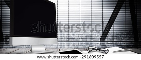 Computer screen against window overlooking city
