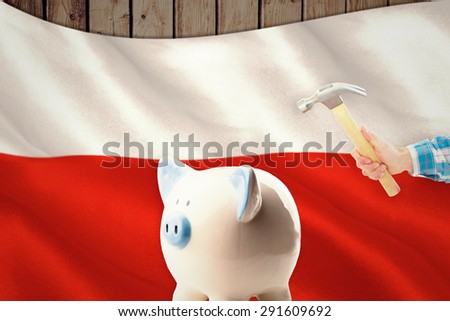 hand holding hammer against digitally generated polish flag rippling
