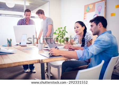 Creative business team gathered around laptops in the office