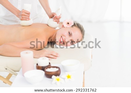 Beautiful blonde enjoying a herbal compress massage at the health spa