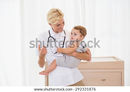 Smiling blonde doctor and child with stethoscope in the medical office