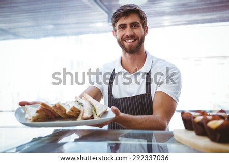 Happy server showing sandwich at camera