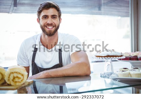 Smiling worker posing behind the counter at the bakery