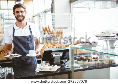 Smiling worker prepares breakfast at the bakery