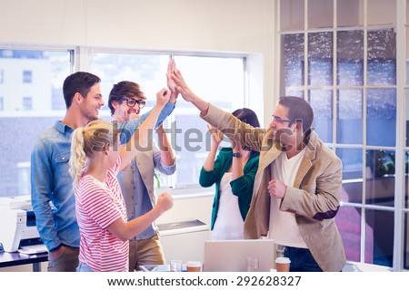 Happy business team doing hands checks in the office