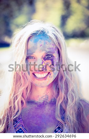 Pretty blonde covered with powder paint on a sunny day