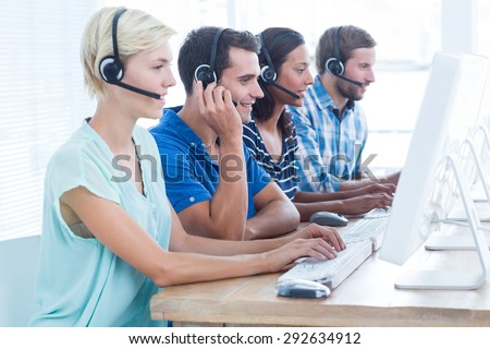 Happy call centre workers on their laptops