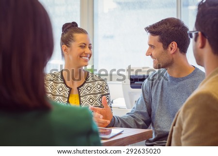 Smiling colleagues talking together in the office