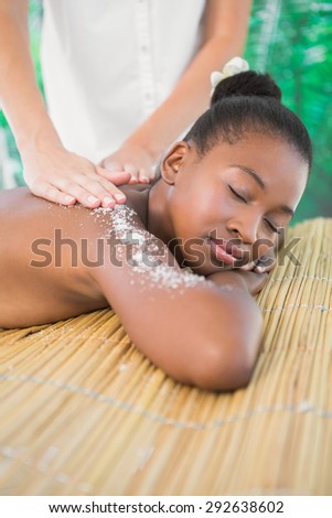 Pretty woman enjoying a salt scrub massage at the health spa