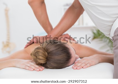 Physiotherapist doing back massage in medical office