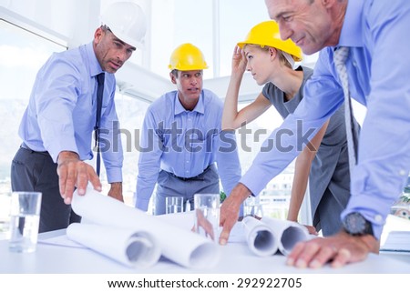 team of business people looking at construction plan in office