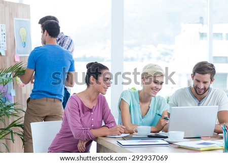 Creative business people using laptop in meeting at office