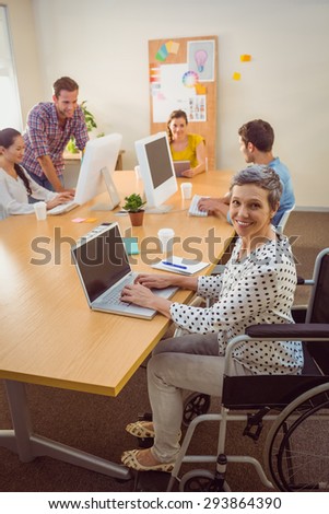 Upward view of a creative casual businesswoman in wheelchair in the office