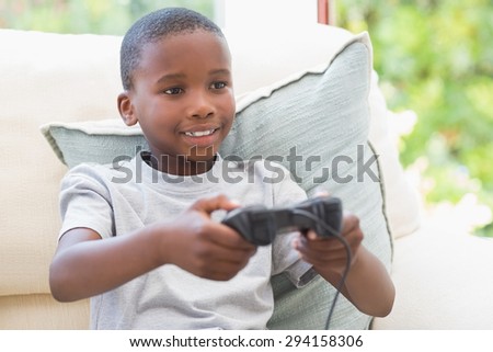 Little boy playing video games at home in the living room