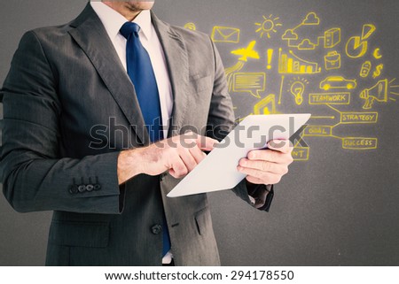 Businessman using his tablet pc against grey background