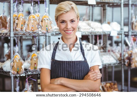 Selfassured female cook smiling in front of her bakery