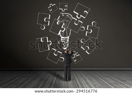 Businesswoman standing with hands on head against dark room