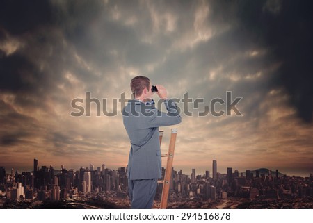 Businessman looking on a ladder against dusty path leading to large city