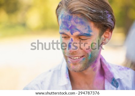 Young man having fun with powder paint on a sunny day