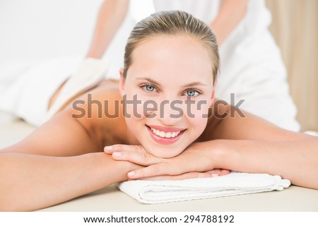 Peaceful blonde enjoying an exfoliating back massage in the health spa