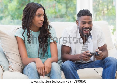 Upset woman being ignored by partner at home in the living room