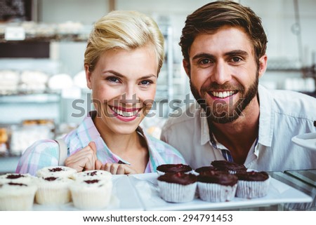 Cute couple on a date looking at the camera at the bakery