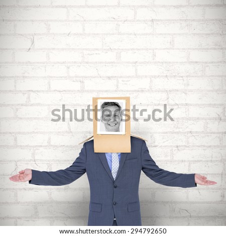 Businessman with photo box on head against white wall