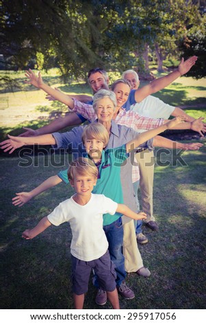 Happy family with arms outstretched in the park on a sunny day