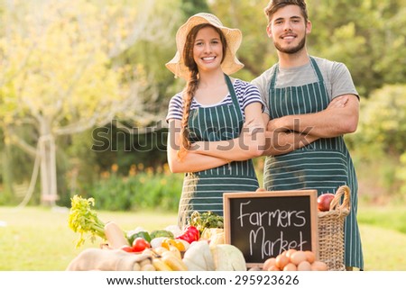 Happy farmers standing arms crossed on a sunny day