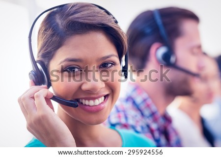 Close up plan of a smiling businesswoman in a call centre