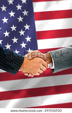 Business people shaking hands against black wall