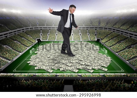 Mature businessman doing a balancing act against pile of dollars