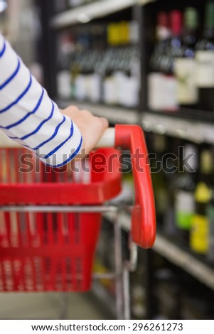 Close up view of hand of woman on trolley at supermarket
