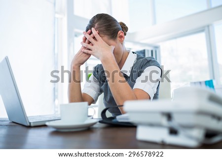 Depressed businesswoman with hands on head in office