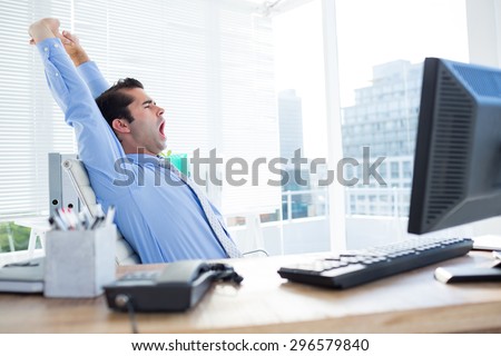 Tired businessman yawning and stretching on his office