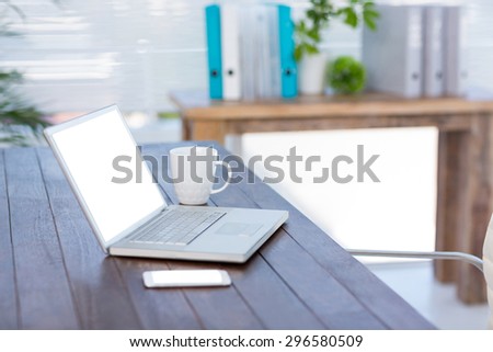 Side view of a business desk with laptop and smartphone