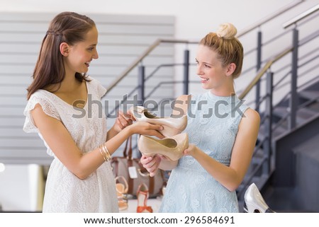 Happy women looking at heel shoes in shoe store