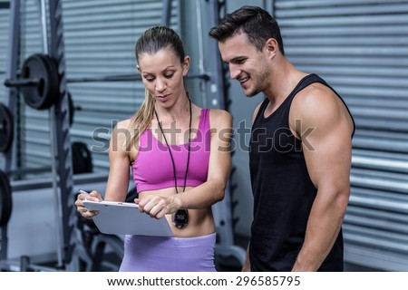 Female coach showing results to an athlete at the crossfit gym