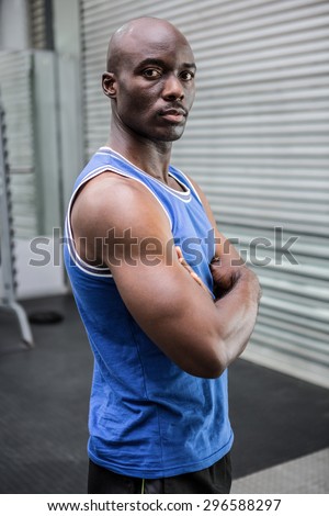 Young Bodybuilder in shirt looking at the camera in the cross gym