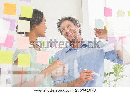Puzzled business team lookingat notes  on the wall in the office
